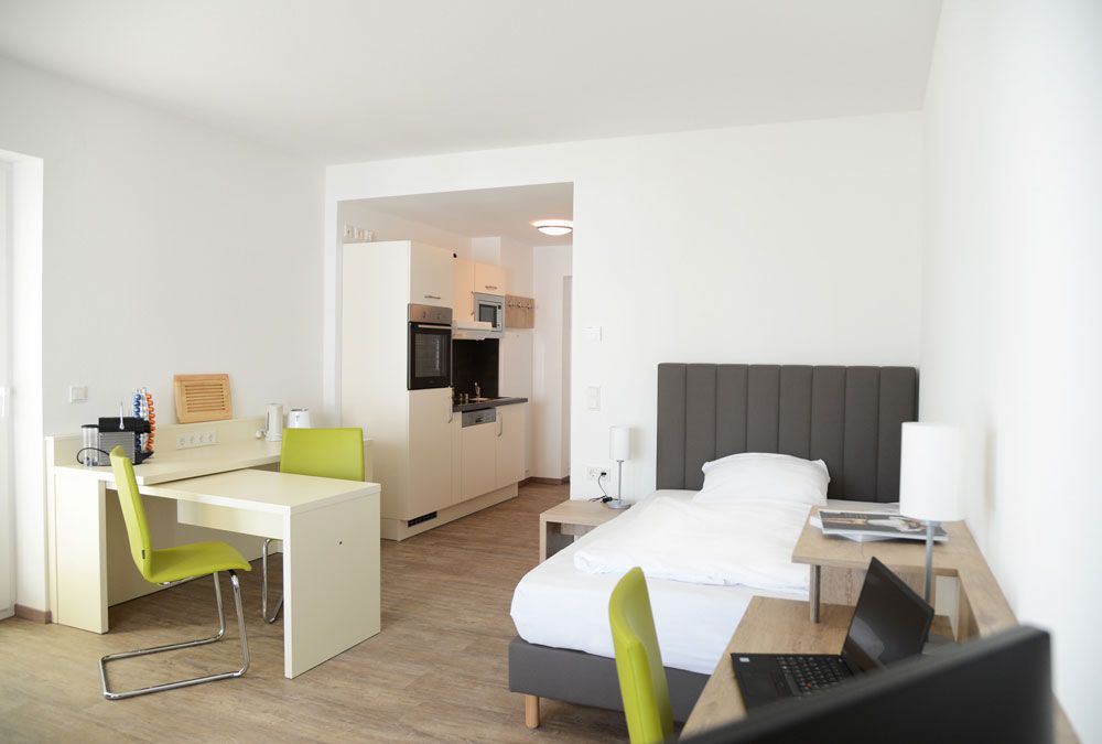 Adapt Businessapartments in Gießen - möbelierten Apartments - Ansicht Bett Schreibtisch Kochnische